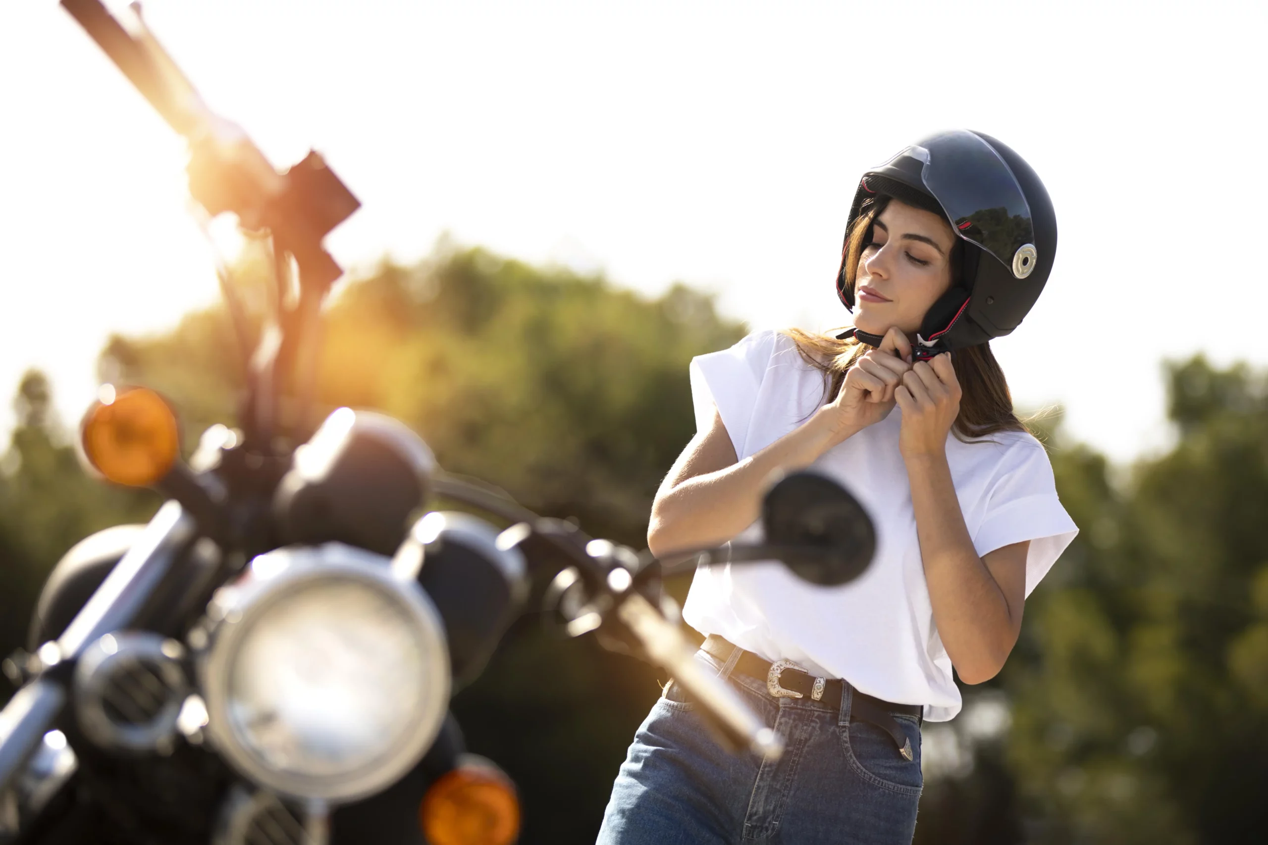 Une femme attache son casque avant de monter sur sa moto, prête pour un trajet en toute sécurité